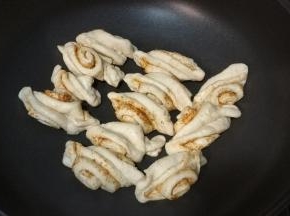 开火，沿锅边里慢慢倒入油煎至底部微黄