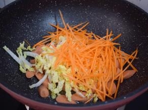 再加入白菜和胡萝卜，翻炒至白菜变软