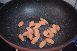 锅中倒入适量的食用油烧热，放入火腿肠翻炒至变色