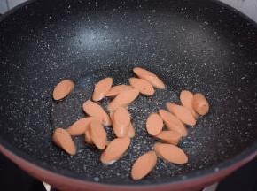 锅中倒入适量的食用油烧热，放入火腿肠翻炒至变色
