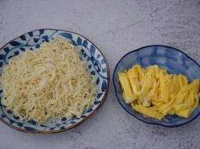 锅中烧开水，放入面条煮熟捞出加入少许食用油拌匀备用，锅中倒入适量的食用油烧热，把鸡蛋液煎成蛋饼取出切丝备用