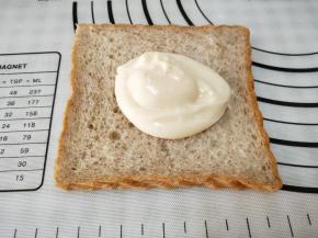 取一张吐司片，放一勺乳酸菌可达酱，对折