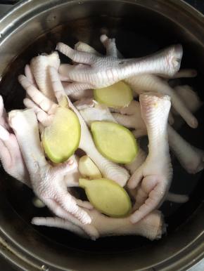 做法超级简单，鸡爪解冻洗净剪去脚指甲，放入生姜和大蒜将鸡爪煮熟放凉。