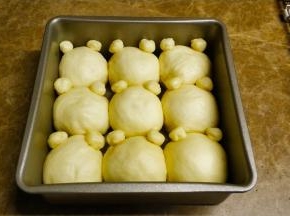 二次发酵好后，小耳朵粘点水粘在每团面团上向。放入烤箱180度20分钟