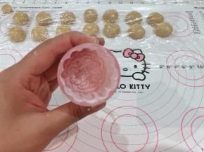 12、月饼模具装好，里面均匀的撒少许玉米淀粉后倒出多余的粉。