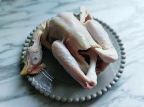 买回来的三黄鸡清洗干净，再用纯净水泡1小时以上，这样做出来的盐焗鸡口感清爽而不腻，浸泡过的鸡淋干水分，把鸡爪放进鸡肚子里。