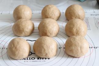 利用虎口的位置，慢慢的把椰蓉陷包入都面内，收口捏紧。所有的都这样制作，并静置一会。