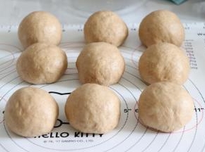 利用虎口的位置，慢慢的把椰蓉陷包入都面内，收口捏紧。所有的都这样制作，并静置一会。