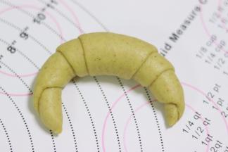 从底边开始往顶角卷起，接口处捏紧，整形成牛角的形状。