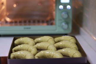 提前预热烤箱，上火180度，下火150度。发酵好的面包，用毛刷涂上蛋液。