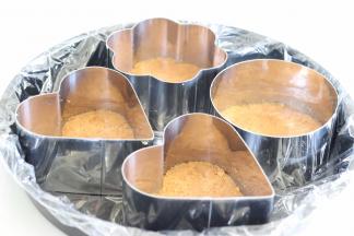 找一个比较平的大盘子，放入慕斯圈，把黄油饼干，放到慕斯圈的底部，压实，压平。做好后，放入冰箱冷藏。