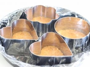 找一个比较平的大盘子，放入慕斯圈，把黄油饼干，放到慕斯圈的底部，压实，压平。做好后，放入冰箱冷藏。