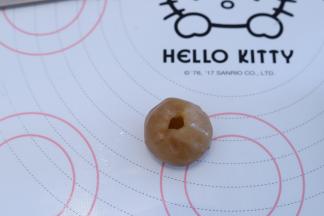 利用手指按住白莲蓉馅中间，捏一小洞