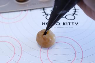 将流心馅放在电子称上，将内陷挤入小洞内，大概为5克左右