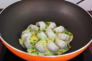 把调均鸡蛋倒入锅中，让蛋液和饺子完美融合，把鸡蛋煎熟，金灿灿即可上桌。