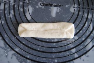 取一个面团，擀成长型，上下1/3对折，再上下端捏合起来。