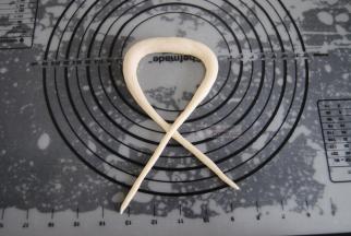 两端交叉，扭一圈，做成普雷结。