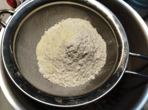 筛入月饼粉跟奶粉，用刮刀压匀。