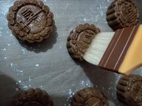 取出月饼，放置手温，用毛刷沾上一点点蛋液，用毛尖的五分之一处，轻轻并且快速的在月饼表面刷几下。