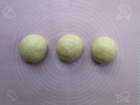 一发后的面团倒在揉面垫上，分割成3等份后分别收圆，然后加盖保鲜膜静置松弛10分钟