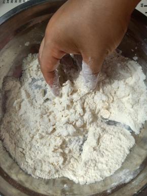 把中筋面粉、白糖、酵母放入和面盆中，用手简单混合一下，倒入一多半的清水，然后根据情况再继续添加剩下的清水。