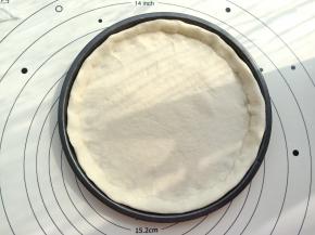 馅料做好之后饼底也差不多醒发好了，取出来看一下如果有蜂窝组织就可以用了。擀成与8寸披萨盘差不多大小的圆形，放入披萨盘中，用手按出边缘部分。