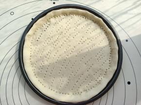 在擀好的饼底上用叉子均匀的扎上眼。烤箱200度预热后。先把饼底放进烤箱烤2分钟。