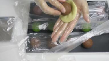 再将饼皮分成20g每个，裹入豆馅儿包圆