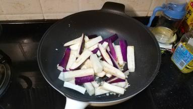锅里热油放入剩下的蒜蓉爆香，倒入茄子条