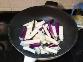 锅里热油放入剩下的蒜蓉爆香，倒入茄子条