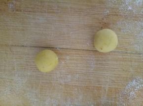 这里给大家演示的是黄色面团的造型做法，取两个2克黄色面团滚圆，压扁，作为维尼熊的耳朵
