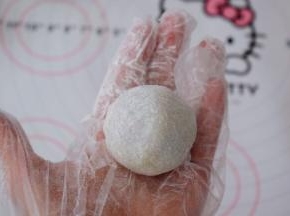 利用虎口慢慢往上推，收紧收口，再揉成光滑的圆球状，表面撒上熟粉