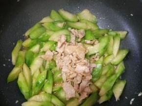 翻炒片刻后倒入猪肉。