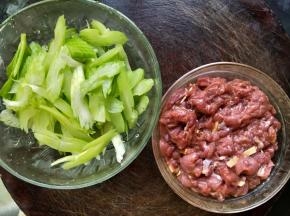 现在开始处理食材:牛肉洗干净切成薄片，加入适量盐、淀粉、料酒、酱油、姜丝、食用油，用手抓匀后腌15分钟左右。
西芹掰成两节，撕去里面的丝，然后切成片。