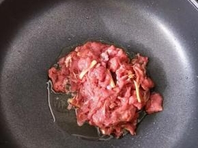 把锅烧热，倒入适量花生油。然后倒入牛肉，大火快速翻炒。