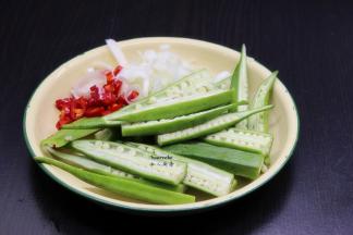 秋葵洗净，去蒂，从中间切开。大葱、辣椒分别洗净，切好。