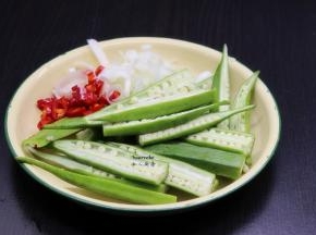 秋葵洗净，去蒂，从中间切开。大葱、辣椒分别洗净，切好。