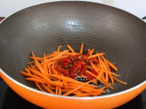 热锅，倒油，要热锅，冷油。倒入切好的胡萝卜丝，然后把泡椒也倒入，翻炒至六成熟，让泡椒炒出味来。