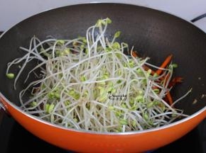 改为大火，把洗净的豆芽沥干水，倒入锅里，翻炒；豆芽比胡萝卜容易熟，要用大火爆炒，豆芽才会爽口。