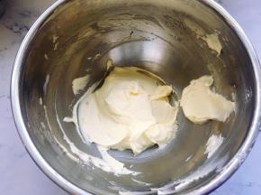 接着用电动打蛋器打发至体积蓬松，黄油颜色变浅。