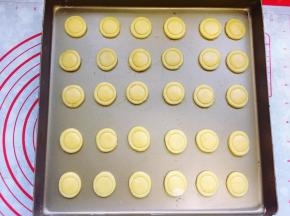 然后用一个小一圈的裱花嘴口在圆片中间压一个浅点的圆圈印子，注意不要压断。