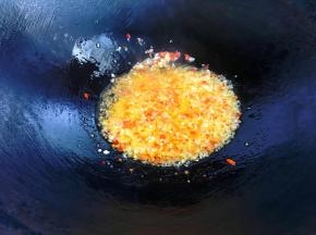 锅里倒入适量油，油温四成热时倒入蒜蓉，小火煸至微黄后加入小米椒继续煸香。