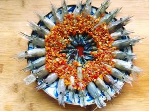 接着将熬好的蒜蓉辣椒酱汁均匀地淋在罗氏虾上。