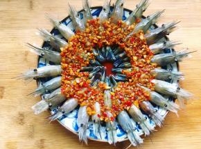接着将熬好的蒜蓉辣椒酱汁均匀地淋在罗氏虾上。