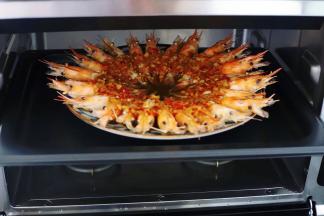 6分钟后关闭蒸烤箱，取出蒸熟的罗氏虾。