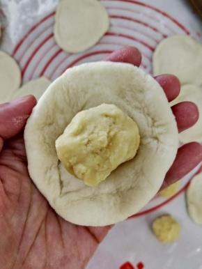 把面团擀成中间后，周围薄的面皮，然后放入适量绿豆馅。