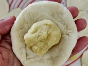 把面团擀成中间后，周围薄的面皮，然后放入适量绿豆馅。