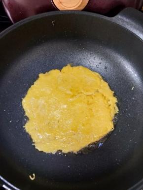 热锅凉油，倒入一半的土豆丝糊，小火煎至底部凝固。