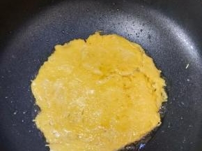 热锅凉油，倒入一半的土豆丝糊，小火煎至底部凝固。