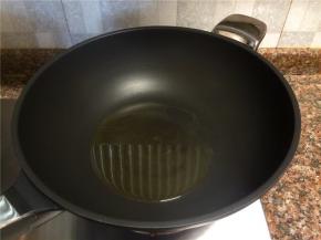 热锅倒油烧至八成热。